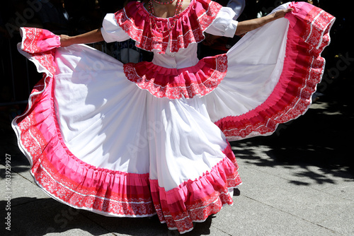 Woman dancing and wearing one of the traditional folk costume from Mexico