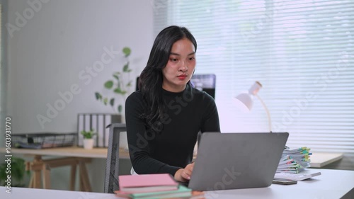 Young asian woman working on laptop in home office