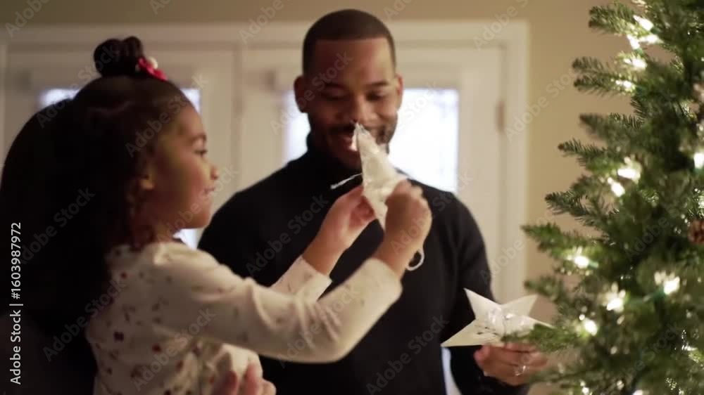 Happy  Father and Daughter Enjoying a Heartwarming Moment Decorating the Christmas Tree Together at Home