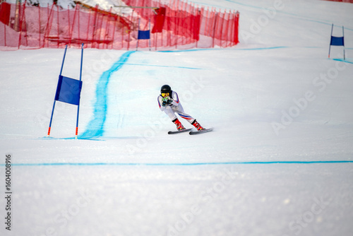 Foto alpine ski athlete racing downhill on snowy ski slope passing blue gate