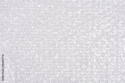 A high-angle, full-frame shot captures the textured surface of clear bubble wrap, showcasing its protective, translucent qualities as a packaging material
