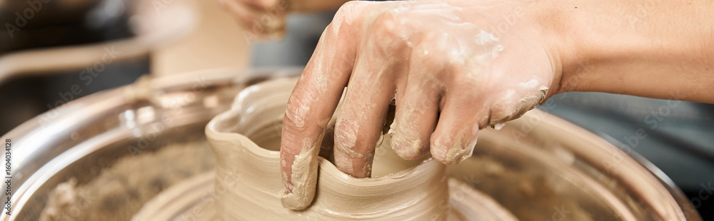 Fototapeta premium Crafting beautiful pottery in a creative studio with a stylish artisan focused on his craft