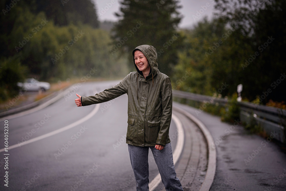 Smiling Woman Hitchhiking in the Rain on Forest Road Smiling Woman Hitchhiking in the Rain on Forest Road