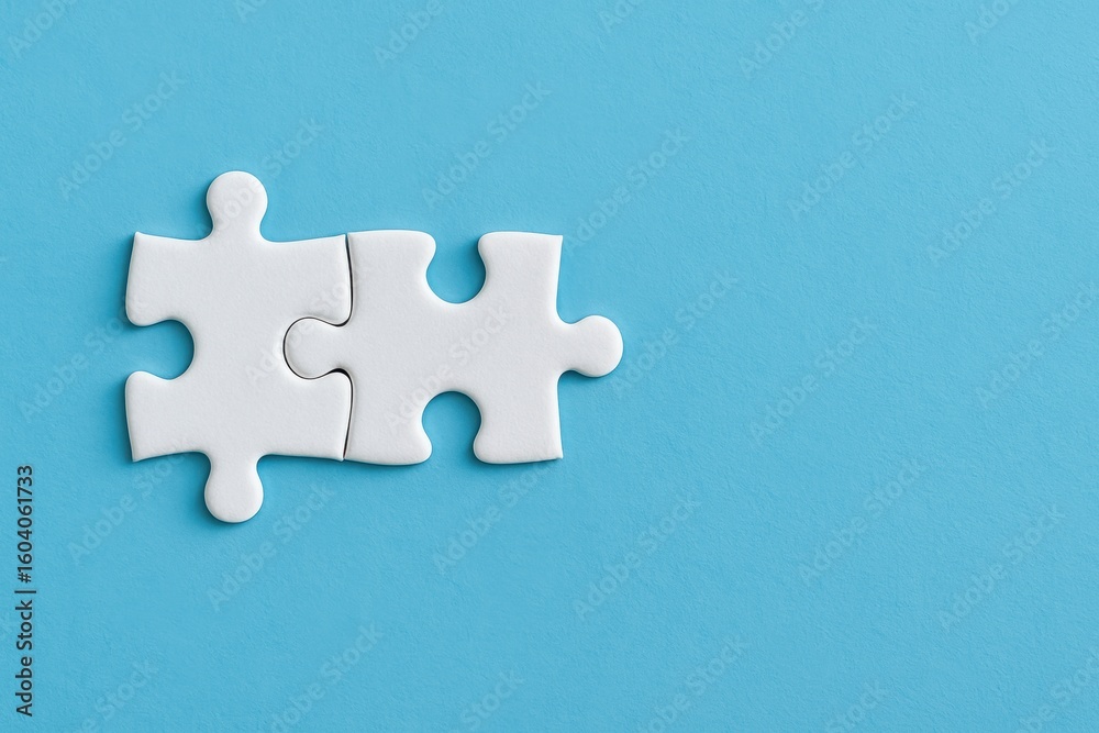 Obraz premium Two Interlocking White Puzzle Pieces on a Solid Blue Background Symbolizing Collaboration, Problem Solving, and Creativity in Business or Education Contexts