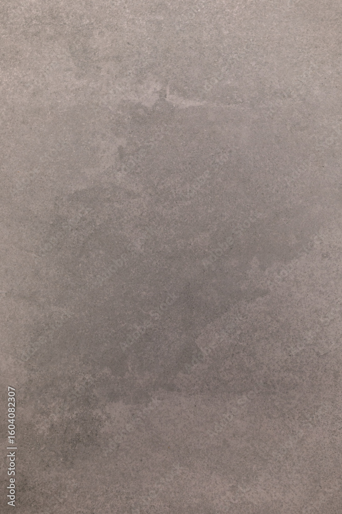 Naklejka premium Wet spot on concrete surface exhibits irregular shape and texture in urban environment during late afternoon