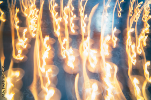 Flames dance in unison under a starry night at a vibrant festival