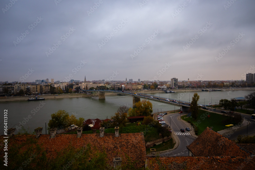 Obraz premium Autumn aerial view of the Danube River and Varadin Bridge from the Petrovaradin side, overlooking Novi Sad, Serbia, on an overcast fall day