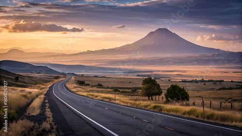 Open Road to Majestic Summit: A scenic drive unfolds as a smooth road winds towards a distant, imposing mountain under a dramatic sky, inspiring journeys.