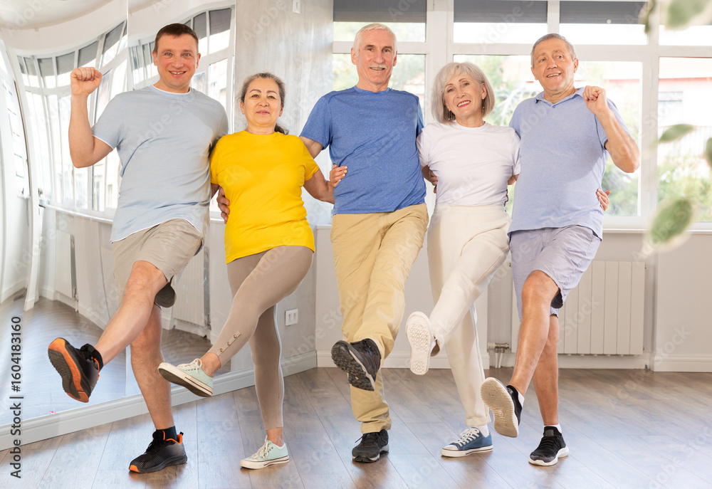 Naklejka premium Positive adults forming line while rehearsing celtic dances in modern dance studio