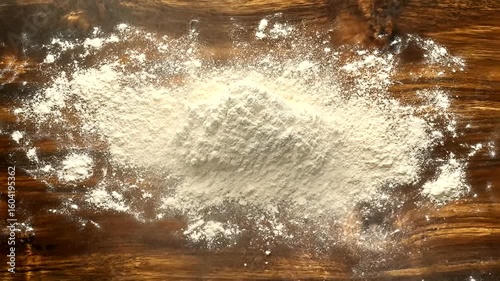 Flour explosion on wooden table top in slow motion, perfect for cooking projects