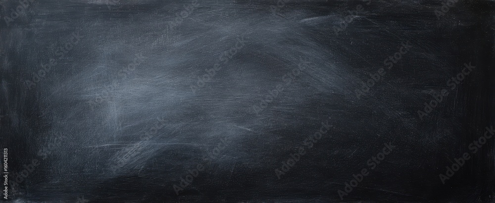 Obraz premium The textured black background featuring a smooth chalkboard surface for creative use.