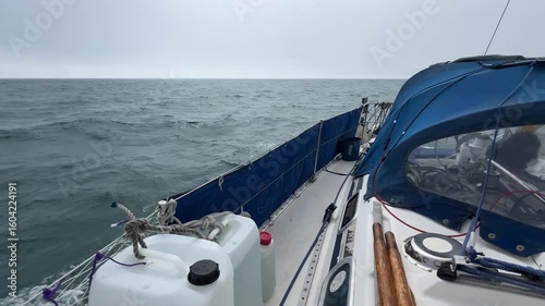 A sailing yacht sailing downwind in light airs at sea, looking aft and to the side of the boat as it gently glides along. A gentle soothing and sophorific motion.