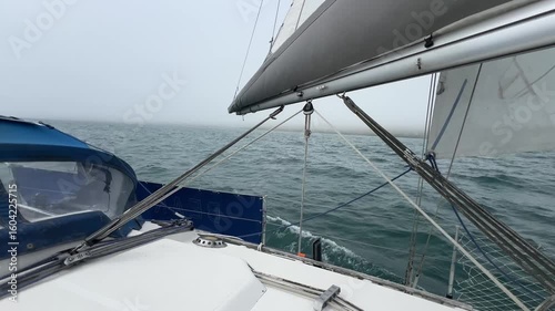 A sailing yacht main sheet and traveller controlling the mainsail as the boat runs downwind in light airs. The mainsheet is attached to the book and controls the angle of the sail to the wind
