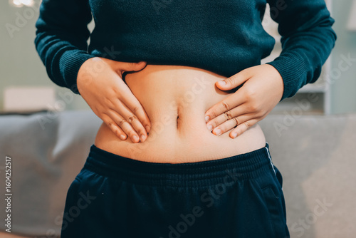 Tableau sur toile woman's hand holding excessive belly fat, overweight concept