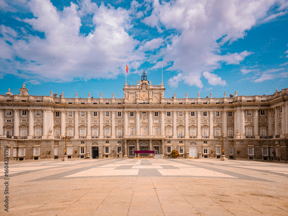 Obraz premium Stunning view of Palacio Real de Madrid under a vivid sky, highlighting its grand architecture and cultural heritage—an iconic destination for travel and exploration in Spain.