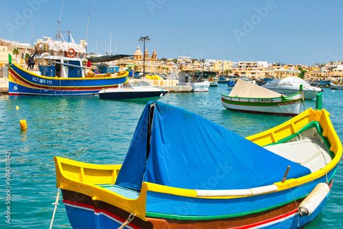 Wallpaper Mural Malta Republic, Malta Island. 28. 06.2023. Marsaxlokk city, The harbour and traditional coloured boats on a hot sunny day. This town has a big market every weekend. Torontodigital.ca
