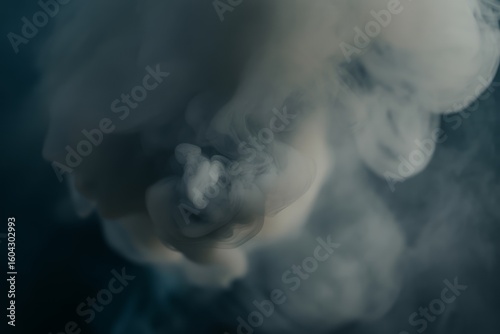 Wispy white smoke plumes against dark background vapor