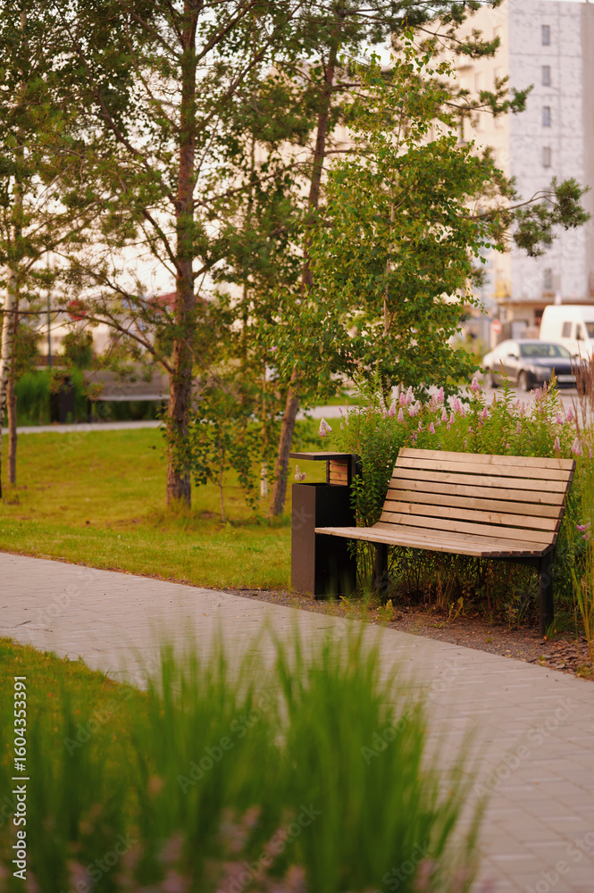 Fototapeta premium peaceful park bench amidst lush greenery offers tranquil escape. urban setting with natural elements, empty seat invites rest. ideal for nature lovers seeking relaxation in city.