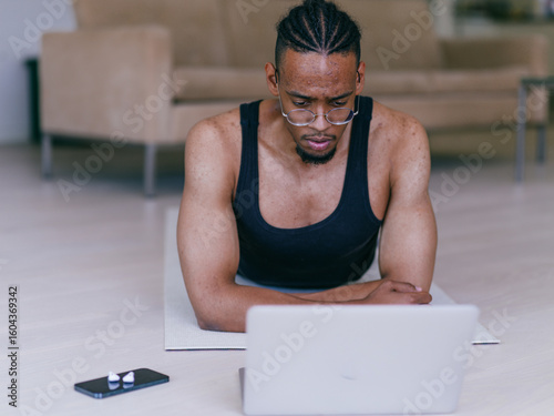 African American Man Watching Fitness Video on Laptop