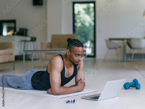 African American Man Watching Fitness Video on Laptop