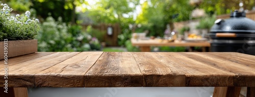 Outdoor wooden table top for product display with a garden and barbecue grill background in a bright and inviting setting ideal for summer gatherings