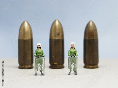 Mini toy of action figure at bullet missile with blurred background. Miniature diorama photography concept design. Minifigure of military crew with balistic rudal weapon.