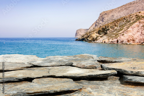 Close up of rocky coast of the sea. Blurred sea, rocky cliff mountain and sky background. Copy space for product placement.