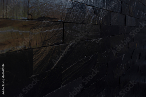 Horizontal vector illustration of dark black brick pattern background. Rough textured rustic background with space for text. No text and no people.