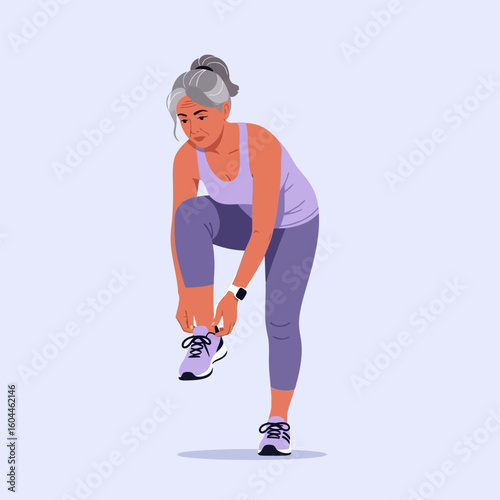Mature Woman Tying Shoelaces Before Exercising Wearing Athletic Apparel