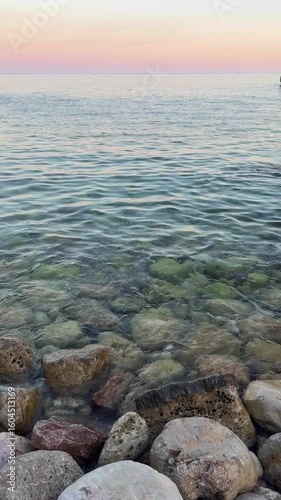 Rocky wild beach surrounded by cliffs in Becici, Montenegro. Coastal landscape, nature tourism, and hidden seaside destination.