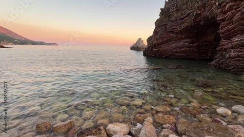 Rocky wild beach surrounded by cliffs in Becici, Montenegro. Coastal landscape, nature tourism, and hidden seaside destination.