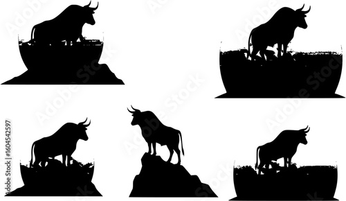 Silhouette of a bull standing on a mountain peak against a large setting sun.
