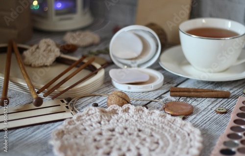 Woman's different things cup of tea, make up, ball clew yarn, mirror doily cozy photo beige pastel light colors