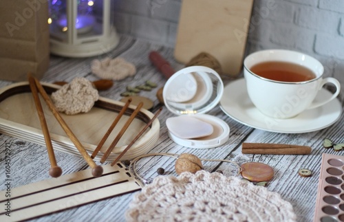 Woman's different things cup of tea, make up, ball clew yarn, mirror doily cozy photo beige pastel light colors