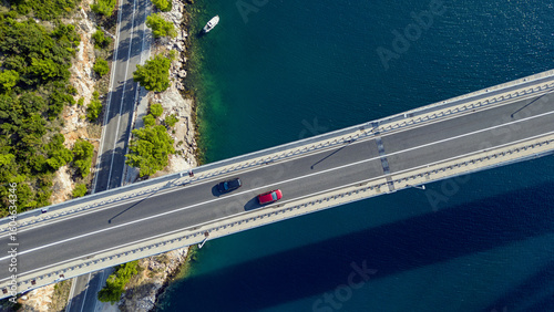 Aerial view of cars traversing a modern bridge, framed by the deep blue sea and verdant coastline, Dubrovnik, Dubrovnik-Neretva County, Croatia.