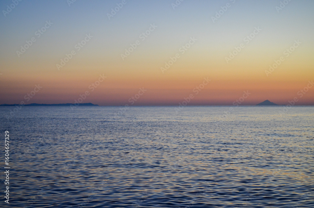 Obraz premium Distant Islands at Twilight Over Tranquil Sea