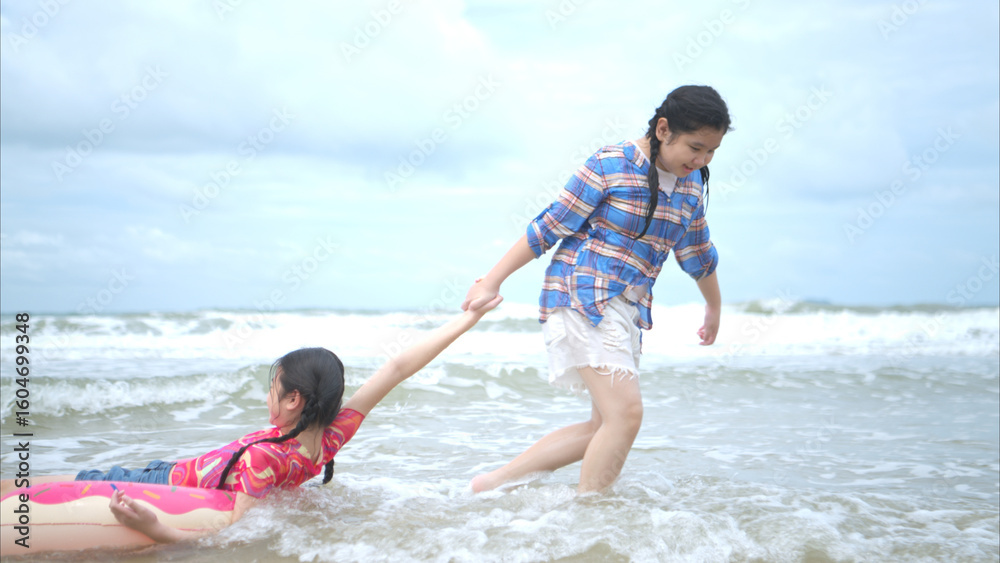 Obraz premium Happy children playing together in the sea, enjoying a fun summer day at the beach
