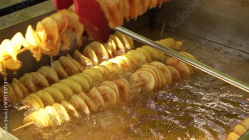 Street food vendor preparing spiral potatoes at a fair