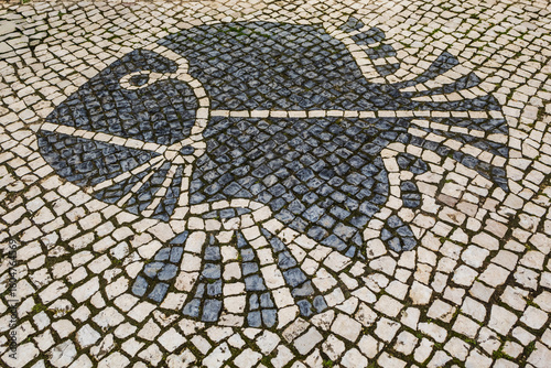 Traditional pattern cobblestone pavement (calçada portuguesa) with fish in Lagos, Algarve, Portugal
