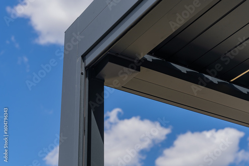 Foto Zoom sur les finitions soignées d’une pergola gris anthracite installée par une entreprise spécialisée, mettant en valeur la qualité de la structure et des matériaux