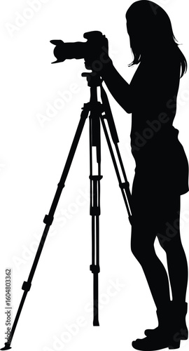 silhouette of a woman taking a photo using tripod