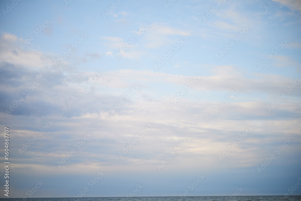 Fototapeta premium Calm sea under cloudy sky at sunset time