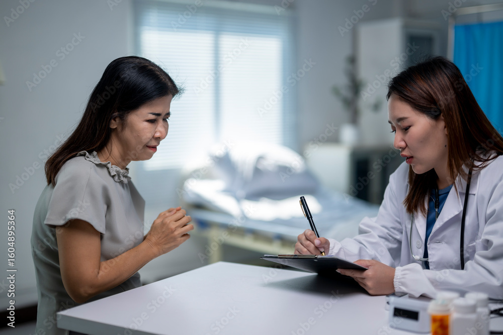 A woman is sitting at a table with a doctor