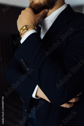 Elegant Preparation: Stylish man in a suit and with a classic gold watch on his wrist.