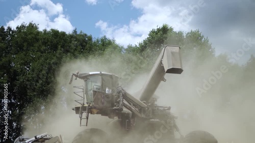 Modern Combine Harvester Operating in Golden Wheat Field during Harvest Season