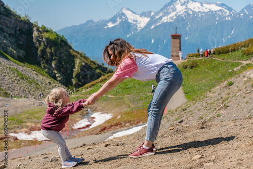Foto A young mother with her three-year-old child daughter goes to the mountains on Krasnaya Polyana in Sochi in the summer