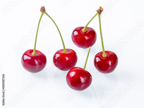 Vibrant ripe cherries placed on a white background captured in side view perspective