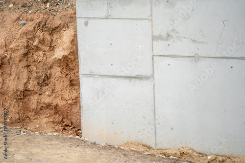 Photography Concrete retaining wall structure with compacted soil support at construction si
