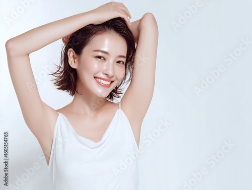 腕を上げて微笑む白い服の美人女性