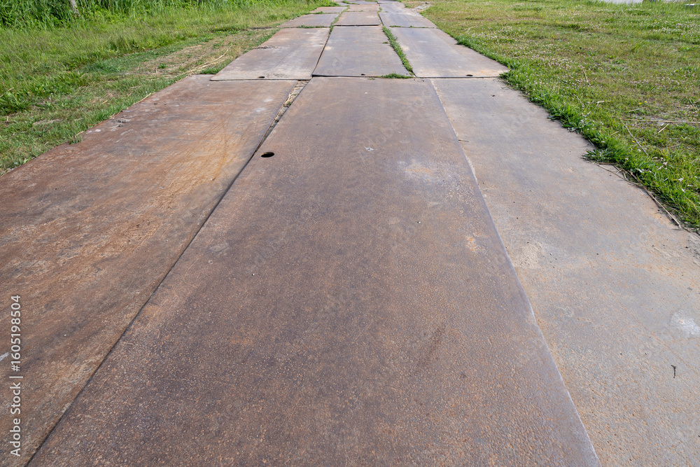 Obraz premium steel plates on a meadow as temporary road